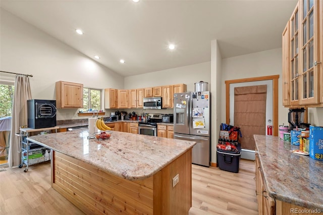 kitchen featuring a center island, light wood-style flooring, light brown cabinetry, and stainless steel appliances