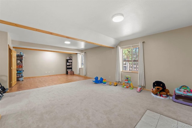 rec room featuring baseboards, carpet, and lofted ceiling