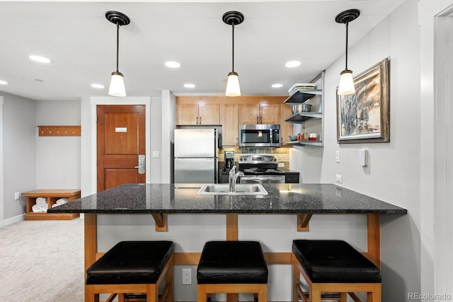 kitchen featuring pendant lighting, stainless steel appliances, a breakfast bar area, and sink