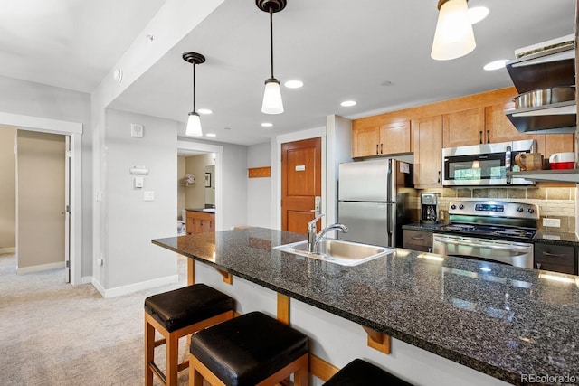 kitchen featuring light carpet, sink, decorative backsplash, appliances with stainless steel finishes, and decorative light fixtures