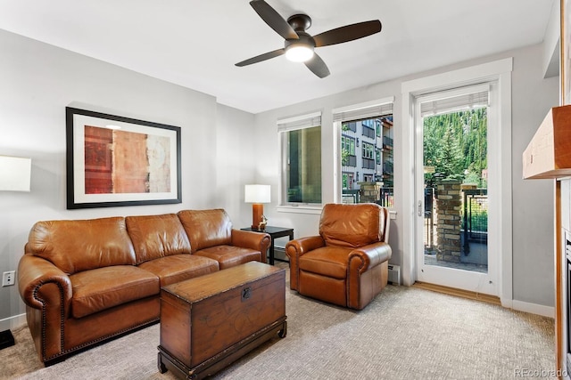 living room featuring ceiling fan, light colored carpet, and a baseboard radiator