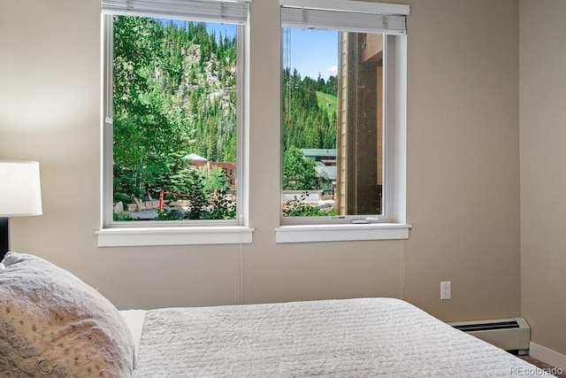 bedroom with baseboard heating and multiple windows