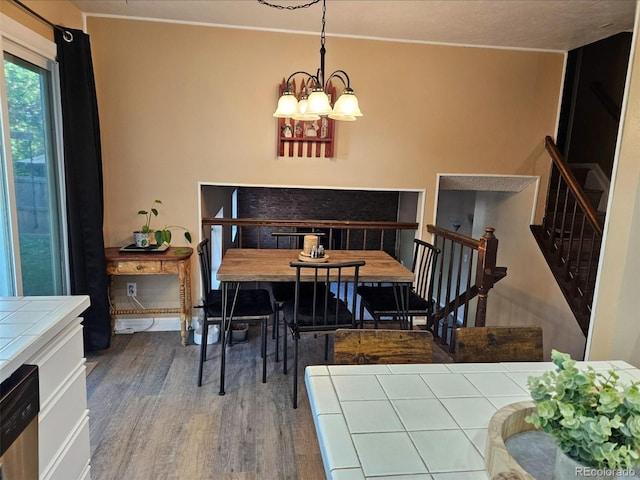 2034 S Truckee St, Aurora, CO 80013 - dining space featuring wood finished floors, a chandelier, and stairway