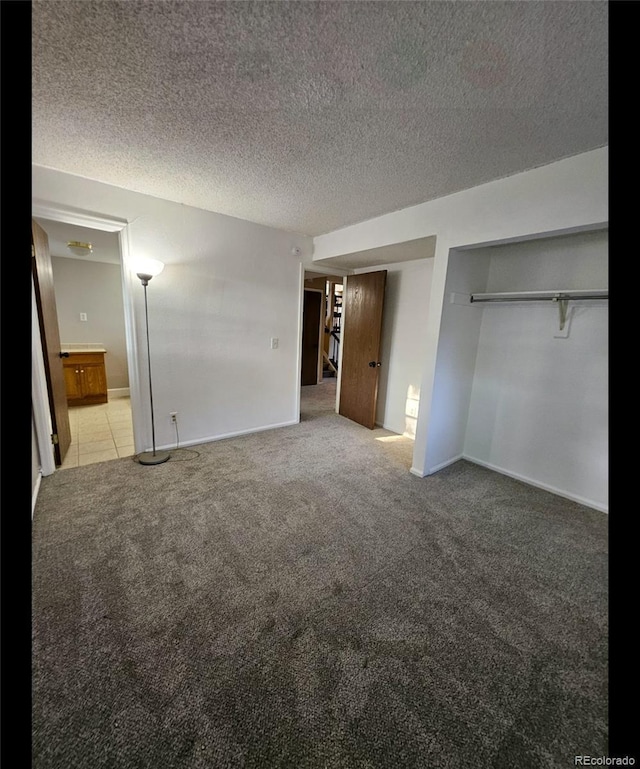 2034 S Truckee St, Aurora, CO 80013 - unfurnished bedroom featuring light colored carpet, a textured ceiling, ensuite bathroom, and two closets