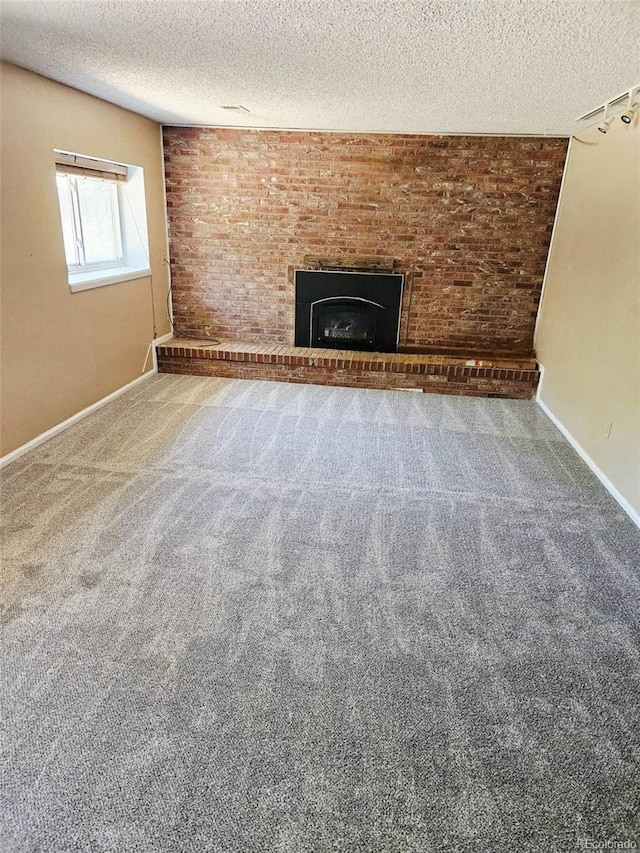 2034 S Truckee St, Aurora, CO 80013 - unfurnished living room featuring a textured ceiling, carpet, and a brick fireplace