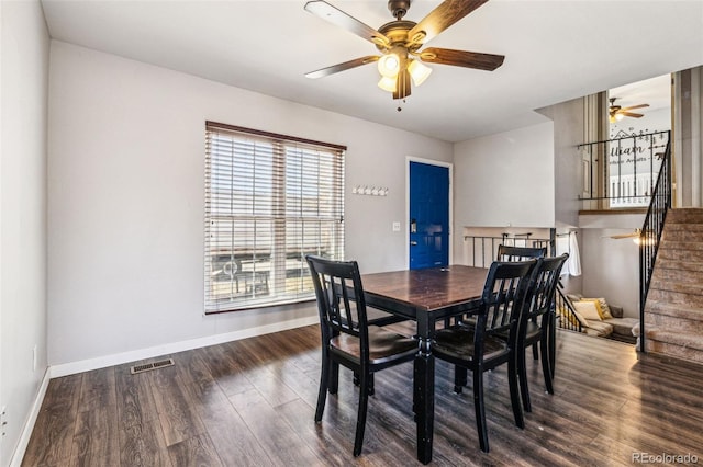 dining space featuring visible vents, ceiling fan, baseboards, stairs, and wood finished floors