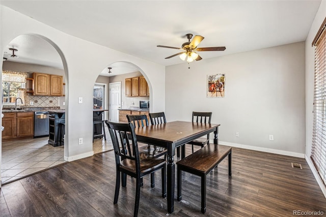 dining space with visible vents, baseboards, dark wood-type flooring, and ceiling fan