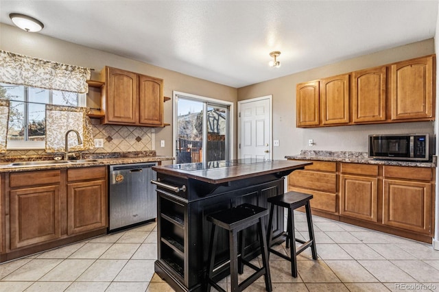 kitchen featuring light tile patterned floors, a sink, appliances with stainless steel finishes, and open shelves