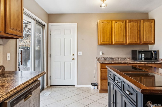 kitchen with dark countertops, light tile patterned floors, baseboards, and appliances with stainless steel finishes