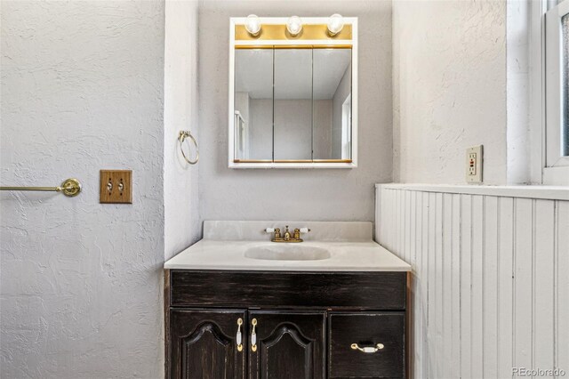 bathroom featuring vanity and a textured wall