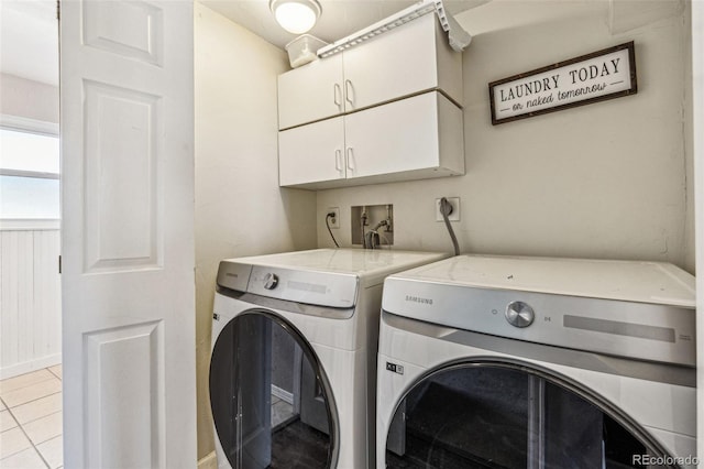 laundry area with light tile patterned flooring, washing machine and dryer, and cabinet space