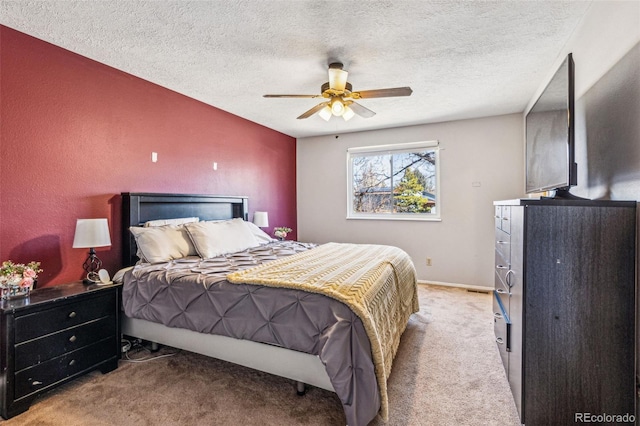 carpeted bedroom with baseboards, a textured ceiling, and a ceiling fan