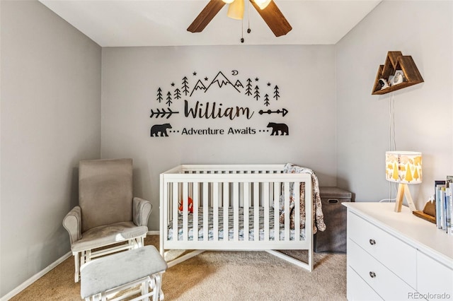 bedroom with a nursery area, light colored carpet, baseboards, and ceiling fan