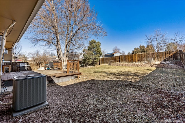 view of yard featuring a fenced backyard, central AC unit, and a deck