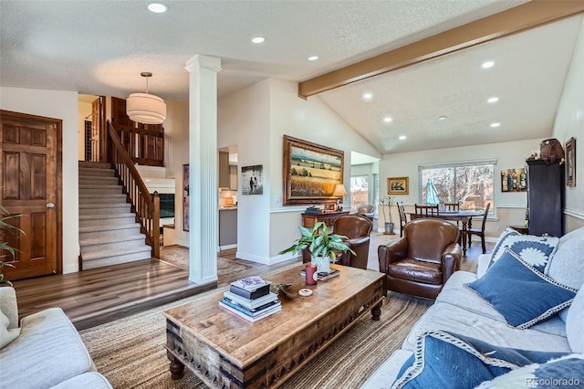 living room featuring vaulted ceiling with beams, a textured ceiling, baseboards, stairway, and decorative columns