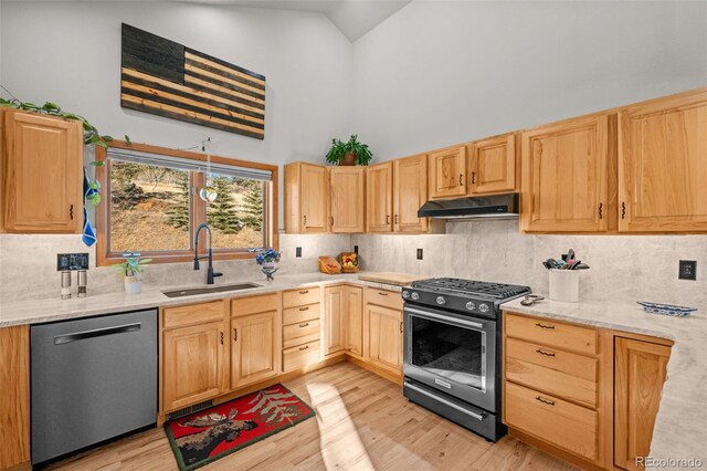 44 Forest Ridge Cir, Bailey, CO 80421 - kitchen with stainless steel appliances, a sink, under cabinet range hood, high vaulted ceiling, and light brown cabinets