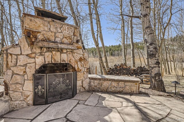 44 Forest Ridge Cir, Bailey, CO 80421 - view of patio / terrace with an outdoor stone fireplace