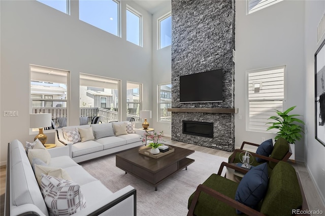 living area featuring baseboards, a fireplace, and light wood finished floors