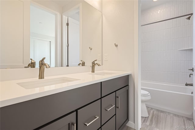 full bathroom featuring toilet, dual vanity, hardwood / wood-style flooring, and bathtub / shower combination