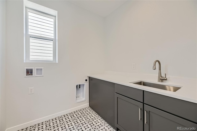 laundry room featuring cabinet space, baseboards, electric dryer hookup, washer hookup, and a sink