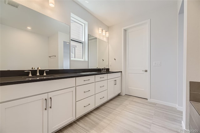 bathroom with tile patterned floors and dual bowl vanity