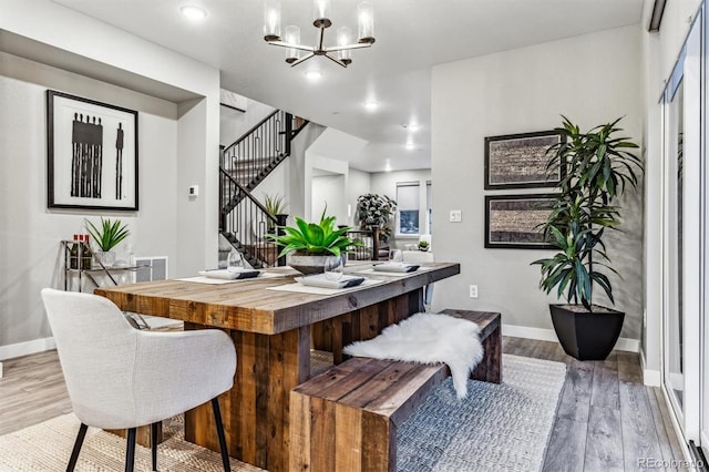 dining space featuring a notable chandelier and light wood-type flooring