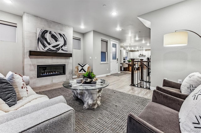 living room with light hardwood / wood-style floors and a tiled fireplace