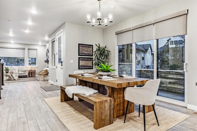 dining room with light wood-type flooring and an inviting chandelier