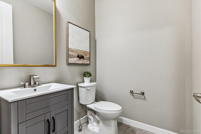 bathroom featuring tile patterned flooring, vanity, and toilet