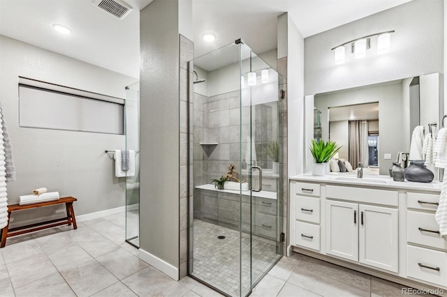 bathroom with tile patterned flooring, vanity, and an enclosed shower