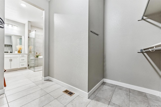 bathroom featuring tile patterned flooring, vanity, and a shower with door