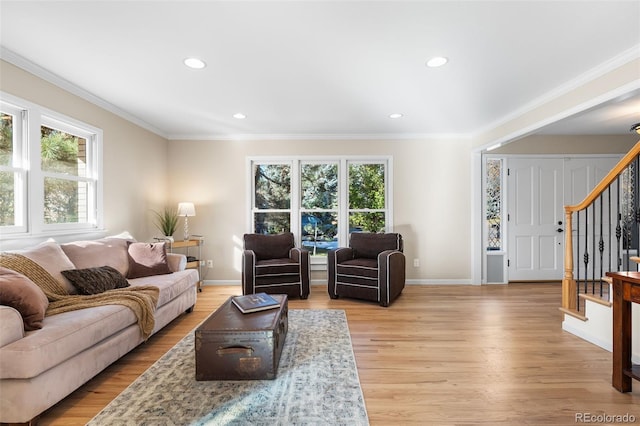 living room with ornamental molding and light wood-type flooring