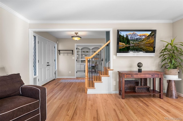 entryway with crown molding and light hardwood / wood-style flooring