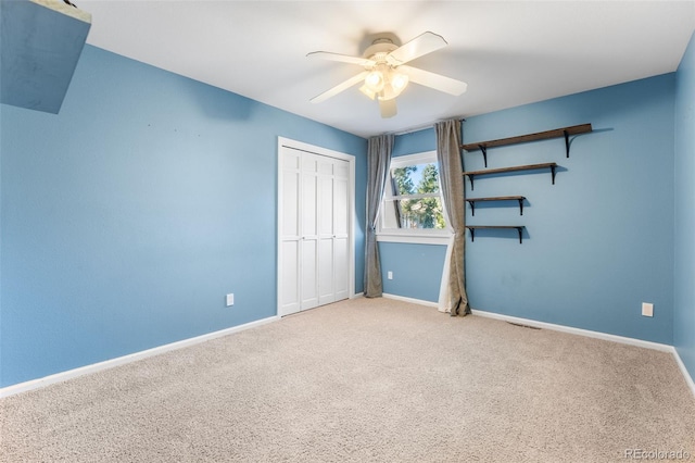 unfurnished bedroom featuring ceiling fan, carpet flooring, and a closet