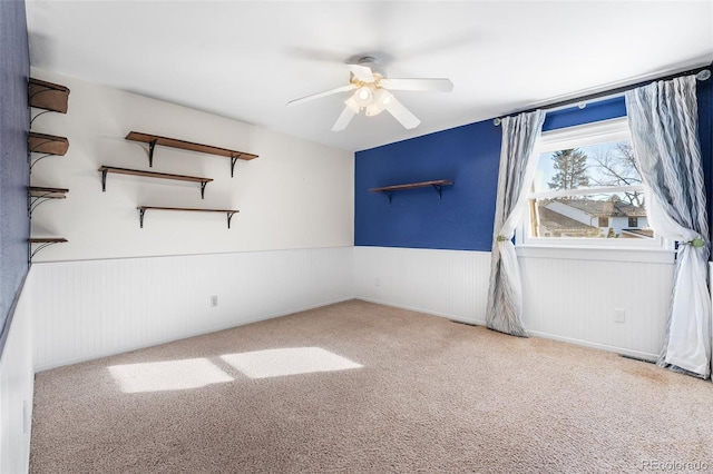 carpeted spare room featuring ceiling fan