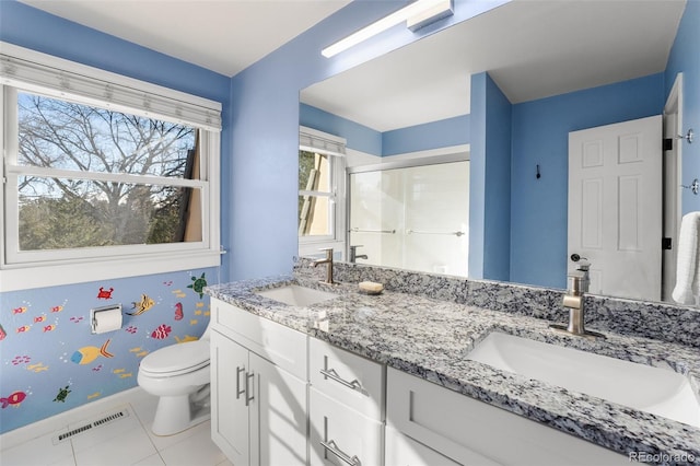 bathroom with tile patterned floors, toilet, a shower with shower door, and vanity