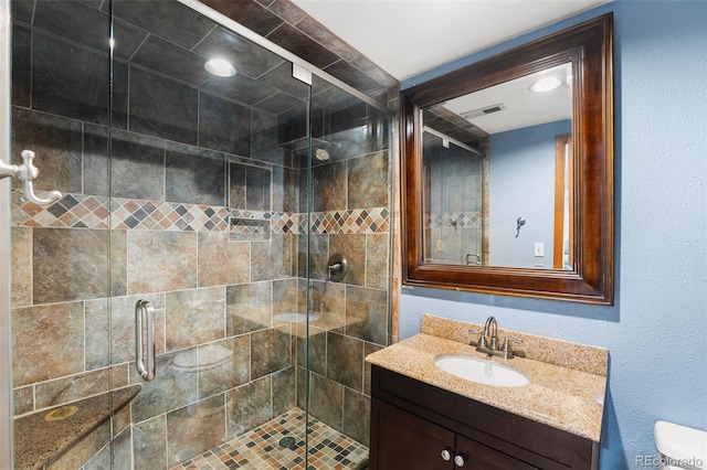 bathroom featuring an enclosed shower, vanity, and toilet