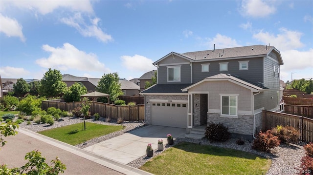 25106 E 1st Ave, Aurora, CO 80018 - view of front of property with driveway, an attached garage, and stone siding