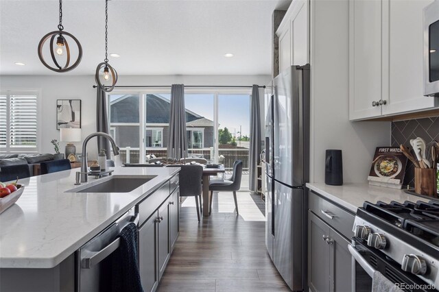 25106 E 1st Ave, Aurora, CO 80018 - kitchen featuring appliances with stainless steel finishes, healthy amount of natural light, decorative backsplash, pendant lighting, and recessed lighting