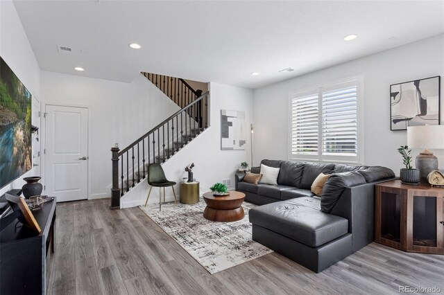 25106 E 1st Ave, Aurora, CO 80018 - living area featuring wood finished floors, stairs, and recessed lighting
