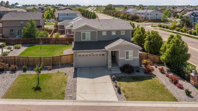 25106 E 1st Ave, Aurora, CO 80018 - view of front of home featuring a residential view, stone siding, concrete driveway, a garage, and roof with shingles