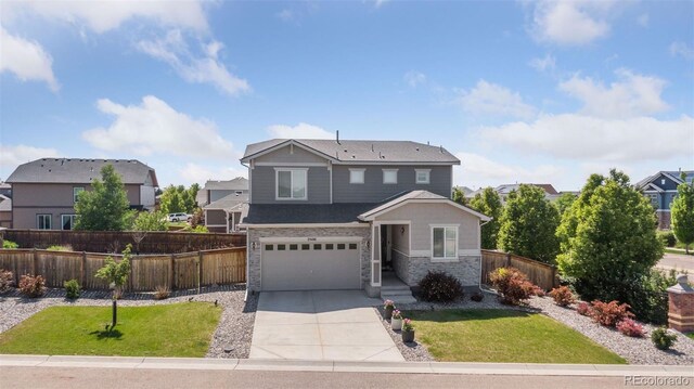 25106 E 1st Ave, Aurora, CO 80018 - view of front of home featuring driveway, a garage, a residential view, and stone siding