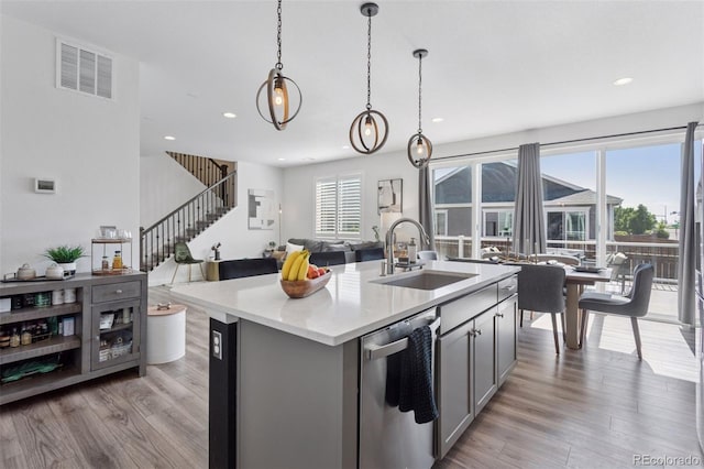 25106 E 1st Ave, Aurora, CO 80018 - kitchen featuring dishwasher, gray cabinets, light wood-type flooring, open floor plan, and pendant lighting