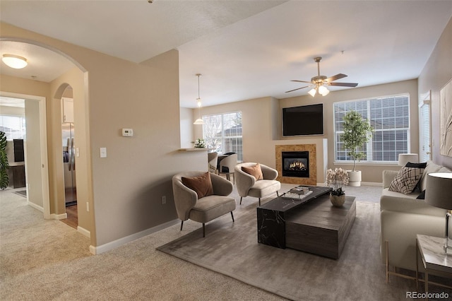 living room featuring carpet flooring, a tile fireplace, and ceiling fan