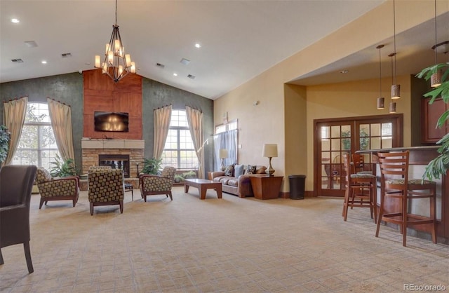 interior space with a stone fireplace, high vaulted ceiling, and a notable chandelier