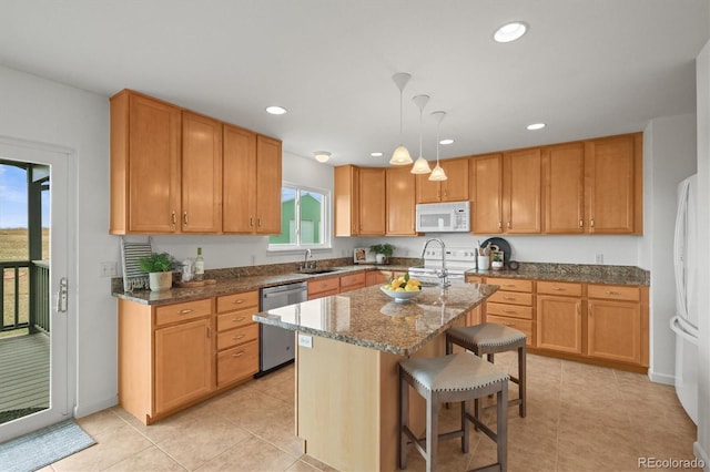 2845 Cherry Way, Parker, CO 80138 - kitchen featuring white appliances, dark stone countertops, a breakfast bar, a center island with sink, and light tile patterned floors