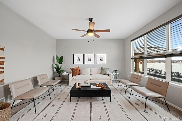 living room with light carpet, a water view, and ceiling fan