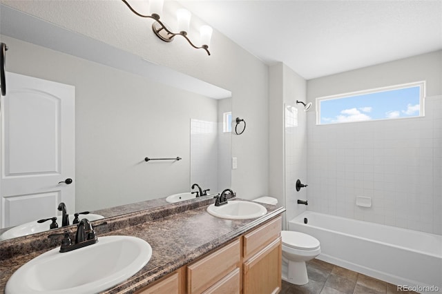 full bathroom featuring vanity, tiled shower / bath, and toilet