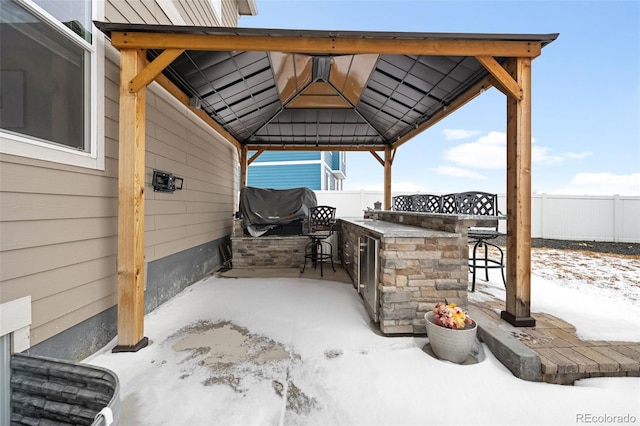 snow covered patio featuring a gazebo and a bar