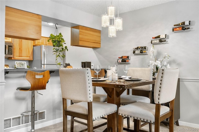 5155 W 68th Ave Unit 5, Westminster, CO 80030 - dining area with baseboards, a chandelier, a textured ceiling, and light carpet